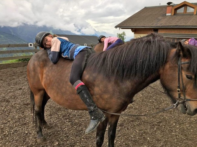 Kinder beim Reiten auf dem Reitplatz - Kinder sitzen verkehrt im Sattel